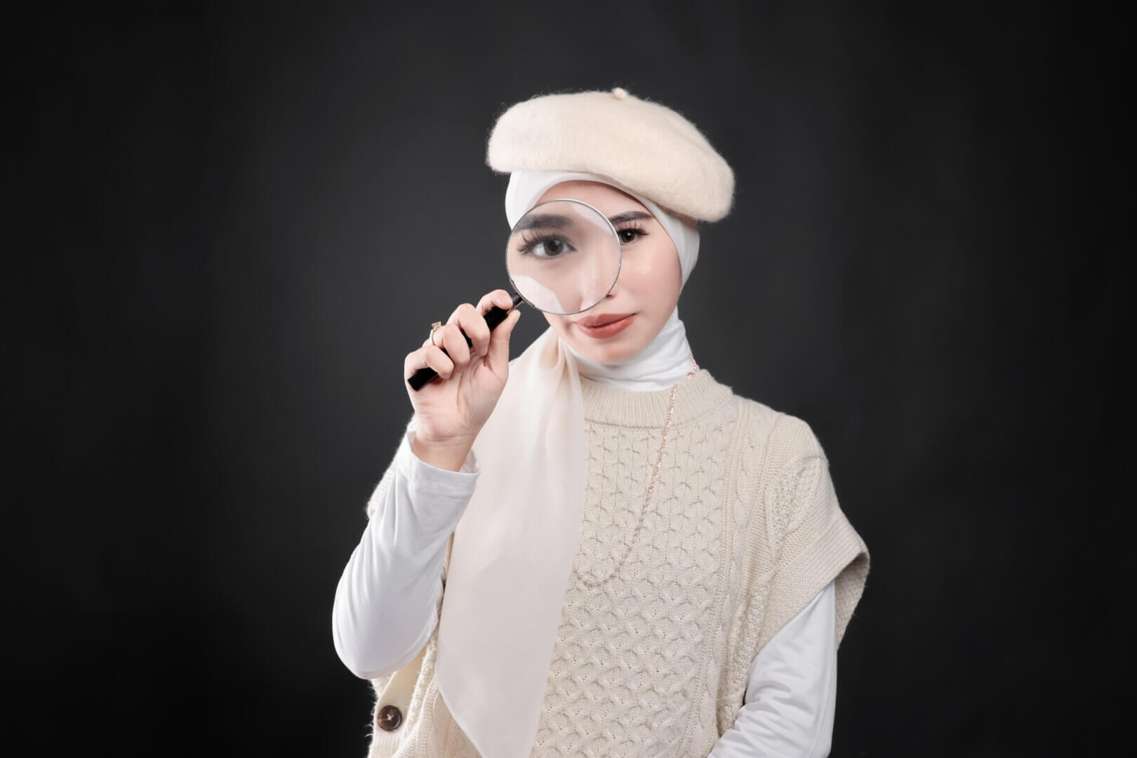 asian,women,in,hijab,over,black,background,holding,a,magnifying