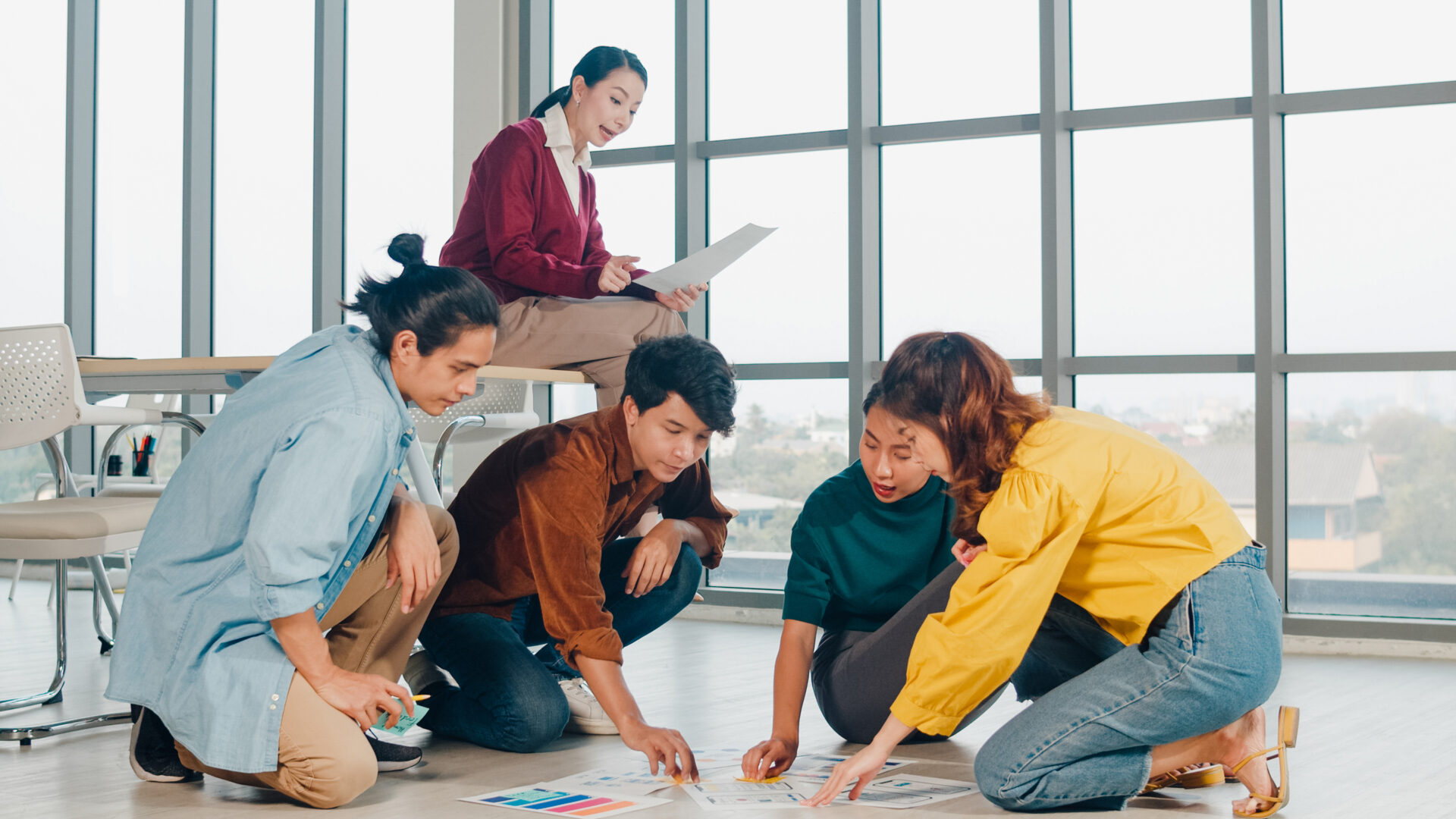 group asia young creative people casual wear discussing business brainstorm meeting ideas mobile application software design project plan laid out floor office coworker teamwork concept