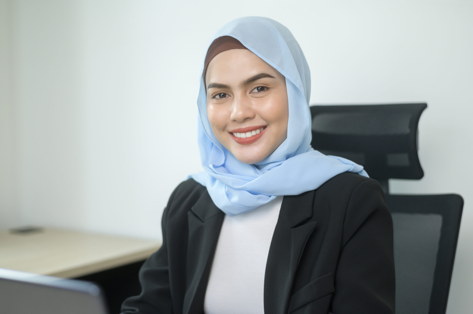young muslim business woman working laptop with documents modern office